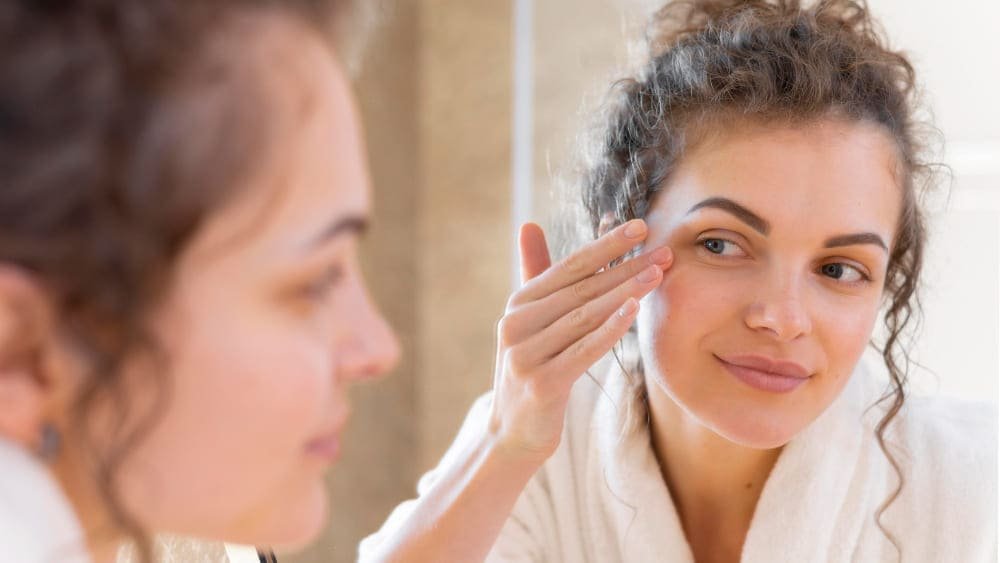girl applies under eye care before applying makeup