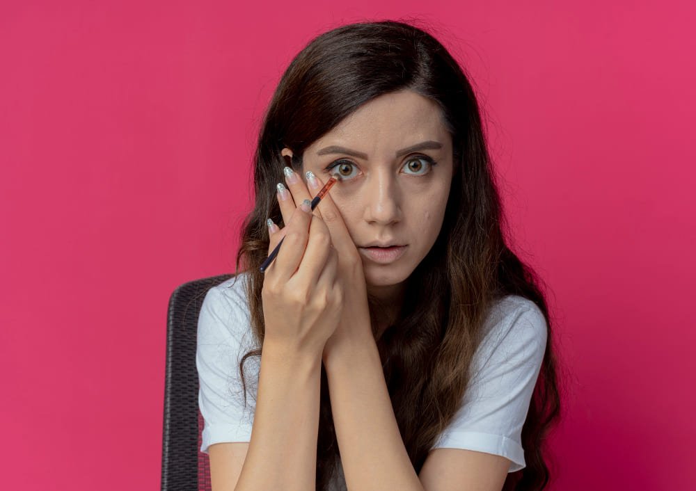 A girl is doing her eye makeup